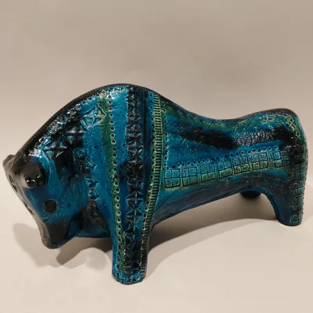 Figurin Tjur, Aldo Londi, ur serien Rimini Blu, Bitossi, Italien, längd ca 32cm, bredd 14,5cm, höjd ca 17cm, chamotterat lergods, blå och grön glasyr, numrerad, nagg/ färgbortfall på båda hornen, krackelering, troligen 1960-tal Skickas med postpaket.