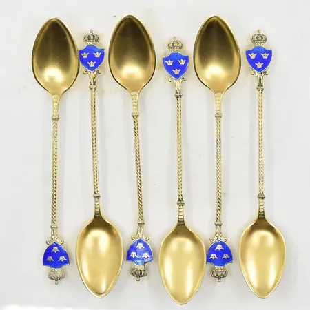 6 skedar med blå emaljsköld i form av tre kronor, C.G.H, längd 11 cm, 1940-tal, förgyllda, 830/1000 silver. Vikt: 68 g