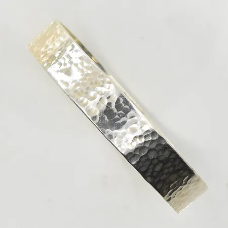 Armring med hamrad dekor, stel modell, innermått 64x61 mm, bredd 12 mm, ojämn/oval passform, 1990-tal, 925/1000 silver. Vikt: 26,9 g