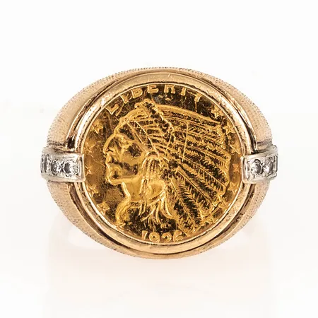 Ring i 14K guld med infattat guldmynt 2½ Dollar "Indian Head - Quarter Eagle" 1926, 21,6K (900/1000), 10 x c:a 0,03ct briljantslipade diamanter. Den är i storlek 20½, är 3,5 - 20 mm bred och väger 14,6g. Viktfördelning 4,1g i 21,6K, 10,5g i 14K. 