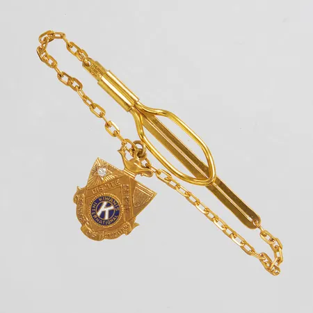 Slipsklämma med berlock samt diamant 1 x ca 0,03ct, längd ca 85mm, bredd 58mm, kedja samt slipsklämma i gulmetall, gravyr, berlock i 14K, bruttovikt: 8,3g.