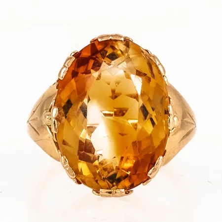 Ring i 18K guld med en citrin 19 x 14 mm. Den är i storlek 16½, är 2,4 - 20 mm bred och väger 8,7g. Stämplad GFM (Juvelerareaffär Gunnar Fahlström, Stockholm), 18K, kattfot. Naggade fasetter men fin lyster ändå. 