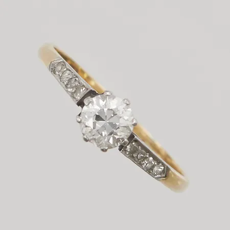 Ring med diamanter, 1x åttkantslipad ca 0,50ct + 8x ca 0,01ct, mittsten med litet nagg i kanten, Ø18, bredd:5mm, något platt skena, 18K 1,8g.