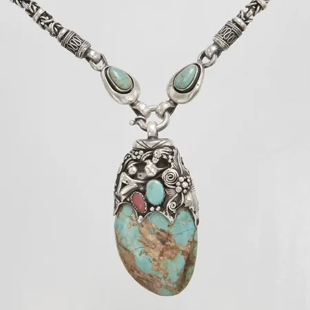 Kedja med hänge turkoser, rubin samt korall, längd ca 47,5cm, bredd 5,5mm, hänge ca 75x36mm, signerad MK, sprickor på turkos, 925/1000 silver, bruttovikt: 137,4g.