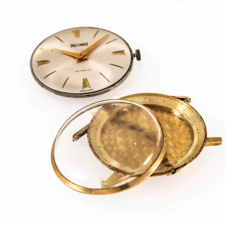 Defekt herrur Precimax i 14K guld utan band. Bruttovikt 19,2g (exklusive urverk 6,9g). Löst glas. Går ej. 