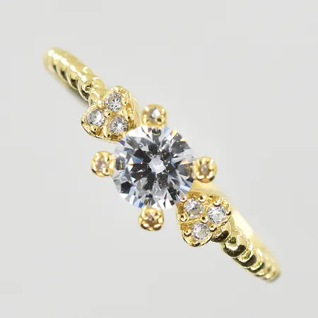 Ring med vita stenar stl:15¾, bredd 1-4mm, ojämn skena,18K. Vikt: 1,3 g