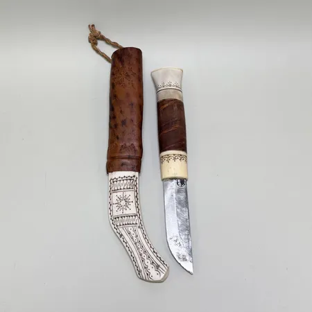 Samekniv längd ca 23cm, bladets längd ca 8cm, slida i ben och läder.