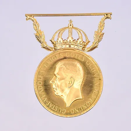 Medalj längd 42 mm, Ø28 mm 18K/22K. Vikt: 13,9 g
