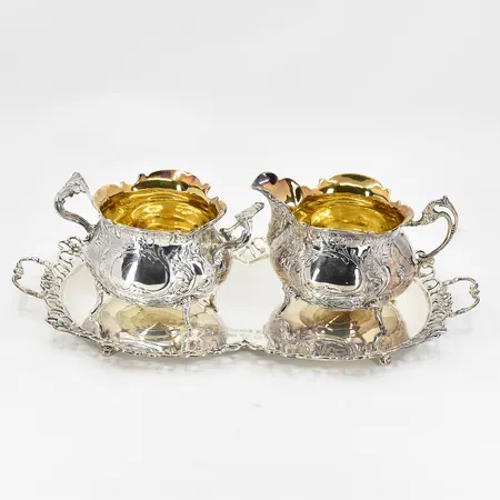 Set med sockerskål, gräddsnipa samt fat, GEWE Malmö, förgylld insida, höjd ca 50mm, längd ca 21cm, bredd ca 12cm, tillverkat C10/1977, fint skick, silver 830/1000 silver. Vikt: 387,9 g