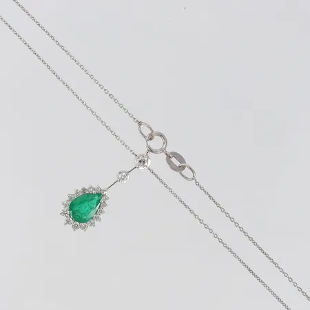 Collier med droppslipad smaragd ca 8,1x5,7x3mm samt diamanter 1 x 0,05ct 1 x 0,02ct 17 x ca 0,01-0,02ct,  längd 39,5cm bredd 0,5-9,3mm, smaragd med spår av färgbehandling vitguld 18K.  Vikt: 2,6 g