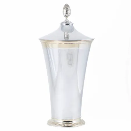 Delvis förgylld pokal i silver med lock. Knopp i form av en kotte. Den är totalt ca 33 cm hög. Öppning Ø 15 cm. Tillverkad 1948 av CG Hallberg i Stockholm. Kattfot. Förgylld insida samt upptill & nertill. Vikt: 669,6g 830/1000. Mikrorepor. 