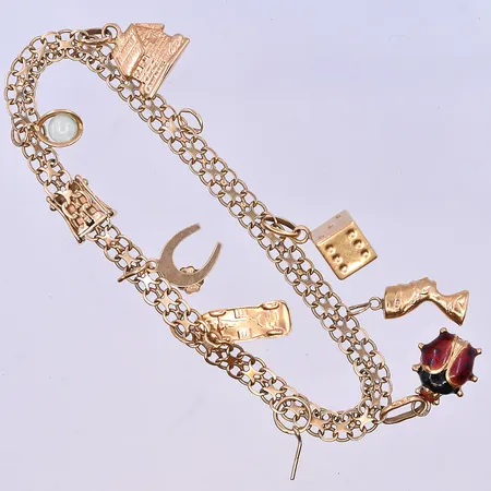Armband X-länk med 8 st berlocker längd 19,5 cm, bredd länk 6 mm 18K. Vikt: 13,4 g