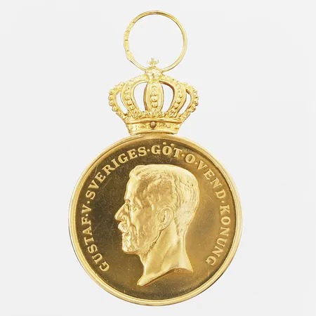 Medalj för långvarig och trogen tjänst, Kungliga Patriotiska Sällskapet, längd 60mm, bredd 36mm, gravyr, krona och ögla i 18K, medalj i 23K Vikt: 29,2 g