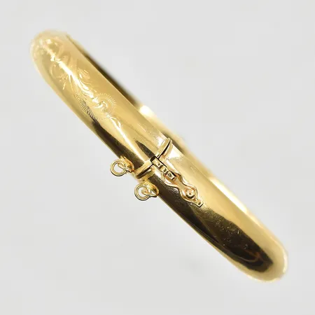 Armring med mönsterdekor, öppningsbar, innermått 58x54mm, bredd 8mm, ihålig, slapp låsåtta, 18K.  Vikt: 16,6 g