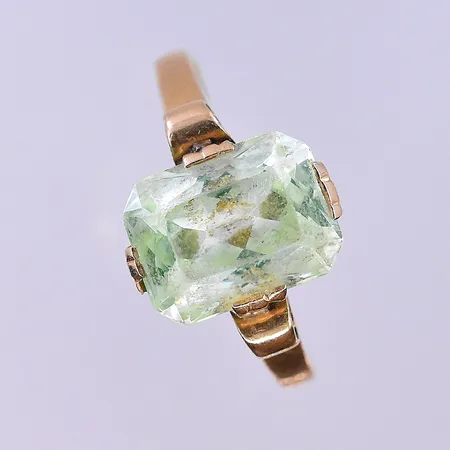 Ring med ljusgrön sten stl:19¼, bredd 2-12 mm slitna facetter 18K. Vikt: 3,4 g