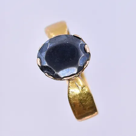 Ring med svart sten stl:19¾, bredd 5 mm 23K. Vikt: 6,1 g