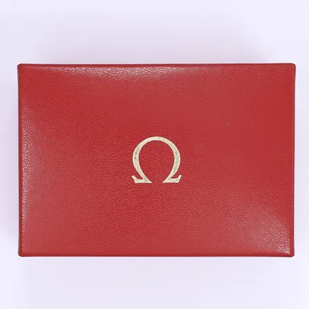 Klockbox Omega 11x7x4cm, troligen 1970-tal, slitage, smältskada framdel Skickas med paket.