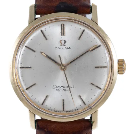 Herrur Omega Seamaster De Ville guld på stål manuell 34,5mm, plexiglas (original), brunt läderband (fläckar), repigt glas, inga tillbehör.