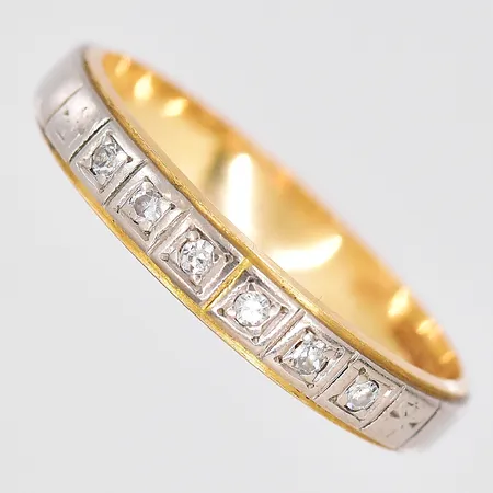 Ring med vita stenar stl:18½, bredd 3mm, gulguld/vitguld, 18K. Vikt: 2,9 g