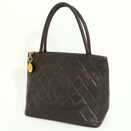 Väska Chanel Medallion Tote lambskin brunt quiltat läder, serienr: 4461439, år 1996-1997, beslag i gulmetall, mått: 30x24x15cm, certifikat från The Brown Paper Bag, slitage på handtag och hörn, torrsprickor, inga övriga tillbehör