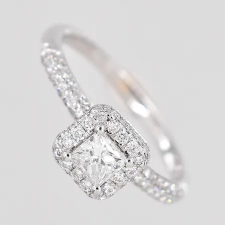 Ring med princesslipad mittsten ca 0,40ct samt briljantslipade diamanter ca 80x0,005ct, stl:17¼, bredd 2-7mm, gravyr, vitguld, 14K. Vikt: 2,7 g