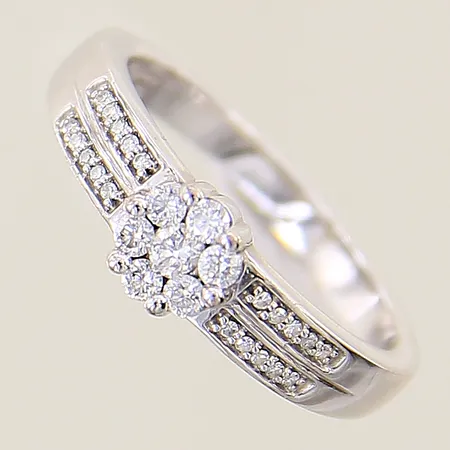 Ring med diamanter 1 x ca 0,03ct, 6 x ca 0,02ct, 20 x ca 0,005ct 8/8-slipade GHA stl:17 bredd 2,4-5,6mm, vitguld 18K Vikt: 4 g