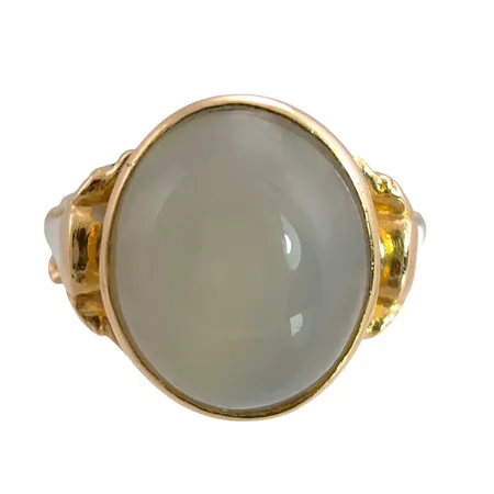 Ring, 18K guld, Månstensliknande sten 9x11 mm, tillverkarstämpel AM, svensk kontrollstämpel, stl:15½ mm, bredd 2,5 - 12 mm, sten utan anmärkning, liten skada i sidodekoren Vikt: 3,6 g