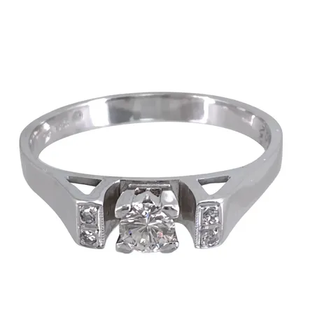 Diamantring, 18K vitguld, Diamanter 1x0,16ct + 4x0,005ct - stämplat på skenans insida, tillverkarstämpel lge, stl:19,0 mm, bredd 3,3 - 3,5 mm Vikt: 3,5 g
