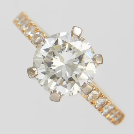 Enstensring med diamanter 1 x ca 2,50ct + 12 x ca 0,03ct ca CR(J)/VS1, stl 17,5, bredd 2,5-9,5mm, höjd 8,5mm, fattning i vitguld, slitna fasettkanter, mindre repor på mittsten, ograverad, 18K Vikt: 6,8 g
