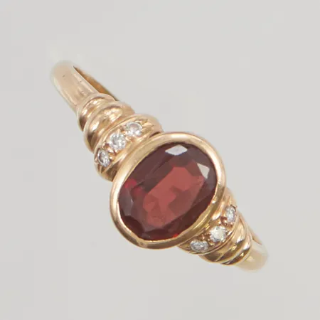 Ring med diamanter totalt 0,05ctv stl:18½ bredd 9mm repig sten troligtvis granat, 18K 2,7g.
