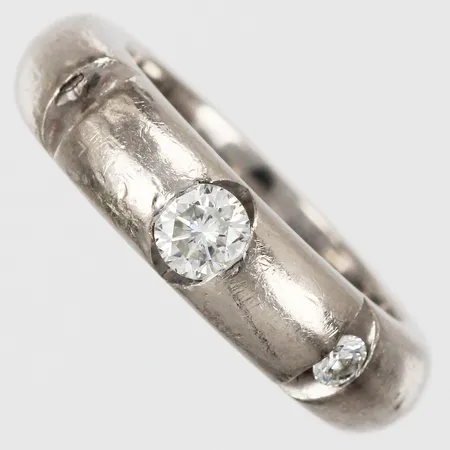 Ring Heribert Engelbert AB 2004 med diamanter ca 1x0,20ct (sitter löst i fattning) samt 1x0,05ct, 1 sten saknas, stl: 15¾, bredd ca 5mm, 18K Vikt: 10,7 g