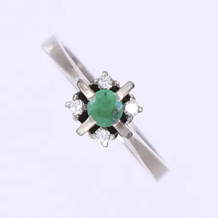 Ring med diamanter 4x0,02ct samt smaragd 1x0,22ct enl. gravyr stl:16¼, bredd 2-7mm, tillv. Schutz Lindahl, Uppsala 1981, vitguld 18K Vikt: 3,6 g