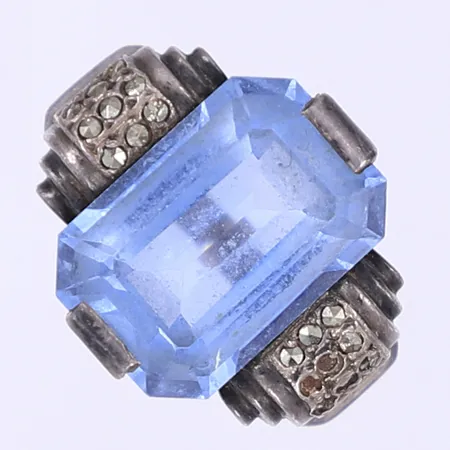 Ring med fasettslipad blå sten och markasiter stl 18¾ bredd 2-16mm obetydlig nagg några markasiter saknas förstärkningsskena silver 830/1000 Vikt: 8,6 g