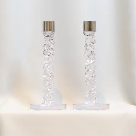 Ljusstakar ett par "Carat" Orrefors formgivna av Lena Bergström, ljushållare i rostfritt, höjd 23,5 cm, fotplatta Ø9,5 cm, etikettmärkta
