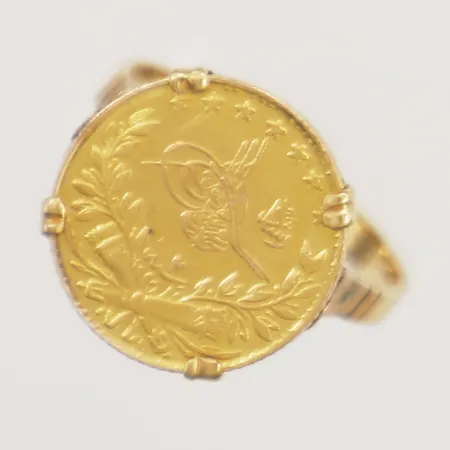 Ring med myntliknande föremål stl:17¾ bredd 2,3mm 18K Vikt: 4,8 g