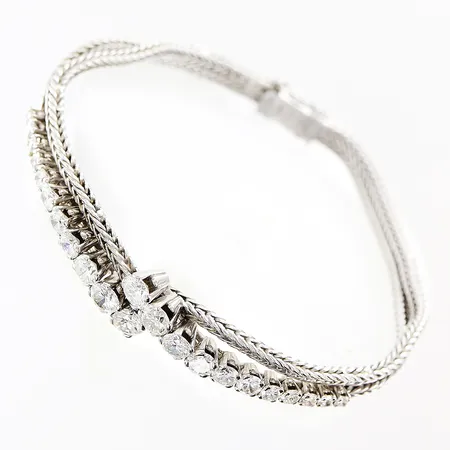 Armband vitguld halvstelt med diamanter, 4 x ca 0,23-0,25ct, 4 x ca 0,16-0,20ct, 4 x ca 0,12-0,14ct, 10 x ca 0,03-0,07ct, längd 17cm, bredd 4-10mm, 18K  Vikt: 17,6 g