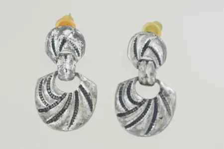 Ett par örhängen längd 3,3 cm bredd 1,2-1,7 cm okänd metall.