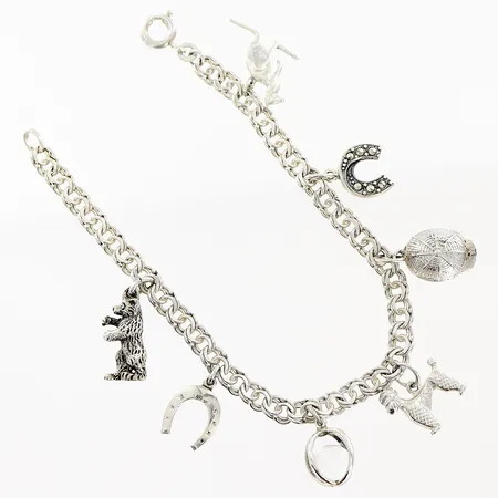 Armband Bismarck längd 18,5cm bredd 4mm, 7 berlocker, svensk importstämpel, silver 830/1000. Vikt: 14,3 g
