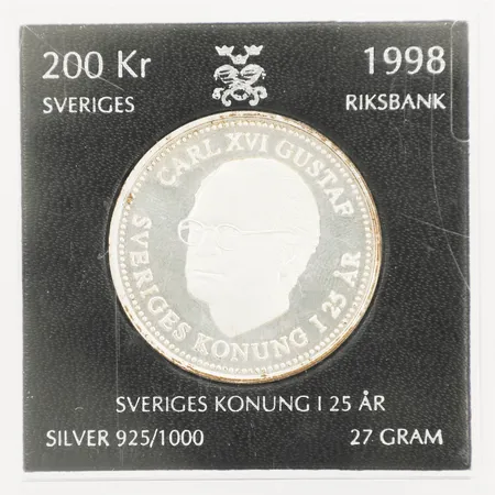 Minnesmynt "Carl XVI Gustaf Sveriges Konung i 25 År, För Sverige i tiden" Nominellt värde 200kr år 1998, etui Silver 925/1000 Vikt: 27,1 g