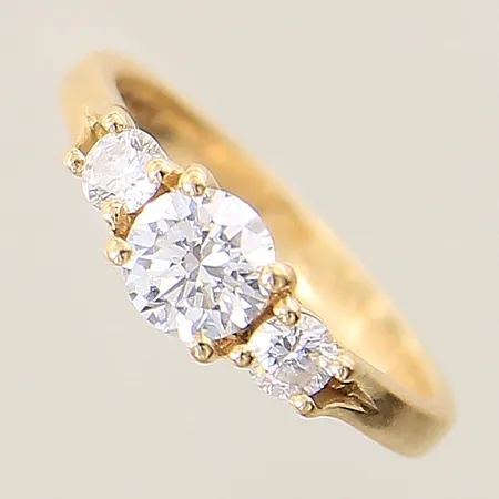 Ring med diamanter 1 x 0,52ct kvalitet TW(F)/VS1 EX/EX/EX med GIA certifikat, lasergraverad rondist:239492853, 2 x ca 0,10ct, de två mindre diamanter indikerar på att vara syntetiska, stl 15½, bredd 2-5mm, gravyr, 18K Vikt: 2,9 g
