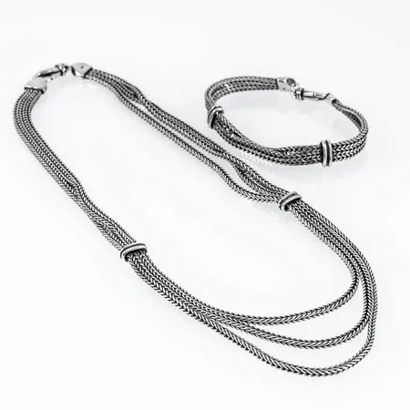 Treradigt set i oxiderat silver: collier 45 cm (den kortaste länken), armband 18,5 cm. Bredd ca 7 mm. Stämplat 925. Framstår oanvänt. Vikt: 60,7g.