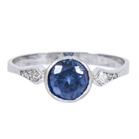 Ring stl:18½ med en syntetisk blå safir 1,48ct och 2 x 0,035, 2 x 0,01ct, 2 x 0,003ct diamanter, kulett, flisor borta från safir, naggade fasetter, certifikat daterad 2006 från CGL, platina i skenan, 14K guld i fattning 2,3g. 