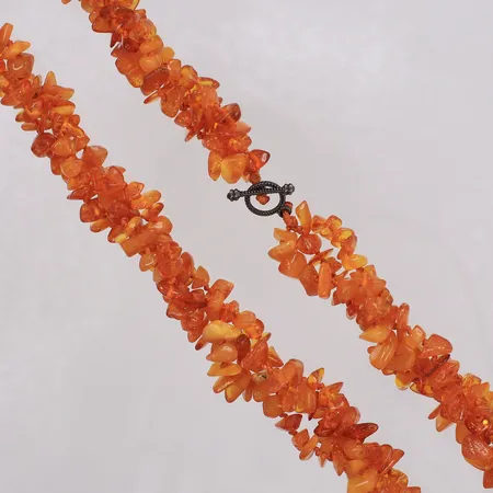 Collier med bärnstenar längd 49cm, bredd ca 15mm, treradig tvinnad tråd, T-lås i oädel metall. 
