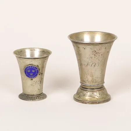 Två bägare, gravyr respektive emalj, höjd: 7cm och 5cm, K. Anderson, 10-tal Stockholm, silver 830/1000  Vikt: 49,7 g