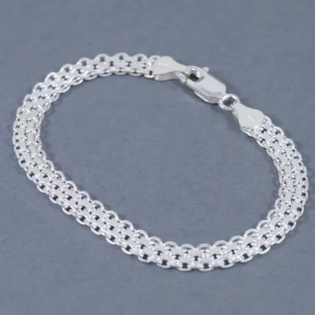 X-länksarmband i silver. Längd 18,4 cm. Bredd 6 mm. Karbinhake. Stämplat 925. Framstår oanvänt. Vikt 7,8g.