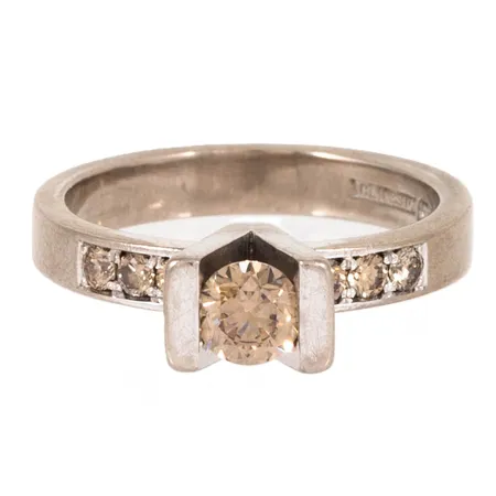 Ring med 1 x ca 0,45ct, 6 x ca 0,03ct briljantslipade coffeediamanter (naturligt bruna diamanter) stl:18 bredd 3,5-5,7mm, vitguld 18K 7,3g. 