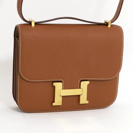 Väska Hermès Constance 18 Epsom 2018, brunt präglat läder med vita stickningar, beslag i gulfärgad metall, märkt Hermès Paris Made in France samt numrerad, ca 18x14x5cm, fint skick, framstår som oanvänd, med tillhörande box och presentsnöre.