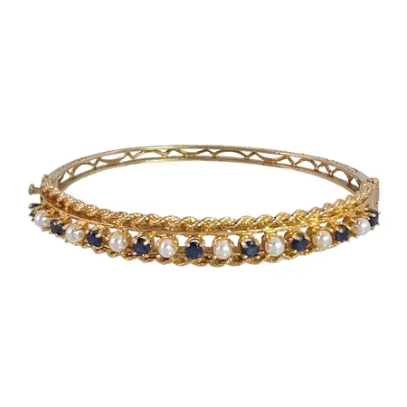 Armring i 14K guld, Safirer Ø 3 mm, odlade sötvattenspärlor Ø 3 mm, mönstrad skena, inre omkrets 16,5 cm, bredd 3,7 - 8,5 mm, fint skick, stenar utan anmärkning Vikt: 13,3 g
