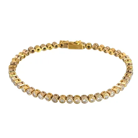 Armband Riviére i 18K guld, Diamanter 51 x 0,03ct, ett fåtal troligen syntetiska, tillverkarstämpel Sadeis, längd knäppt 18,0 cm, bredd 3,3 mm, tjocklek 3,7 mm, fint skick, stenar utan anmärkning Vikt: 15,3 g
