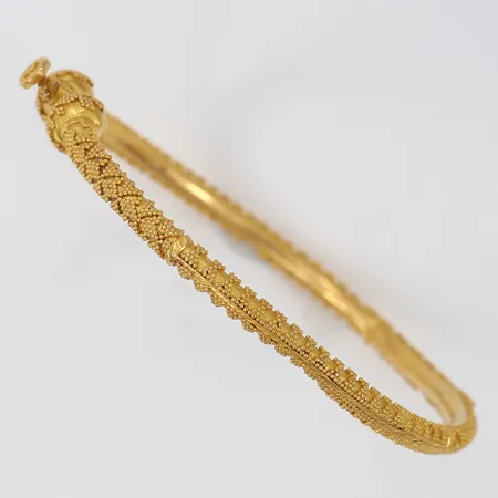 Armring med dekor öppningsbar Ø58mm bredd 3,3mm bucklig lås med slitage 21K. Vikt: 13,6 g